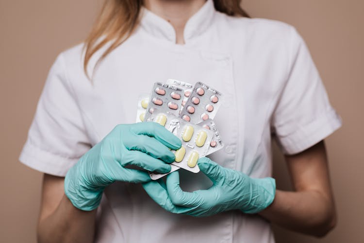 Woman in a white uniform holding various tablets.